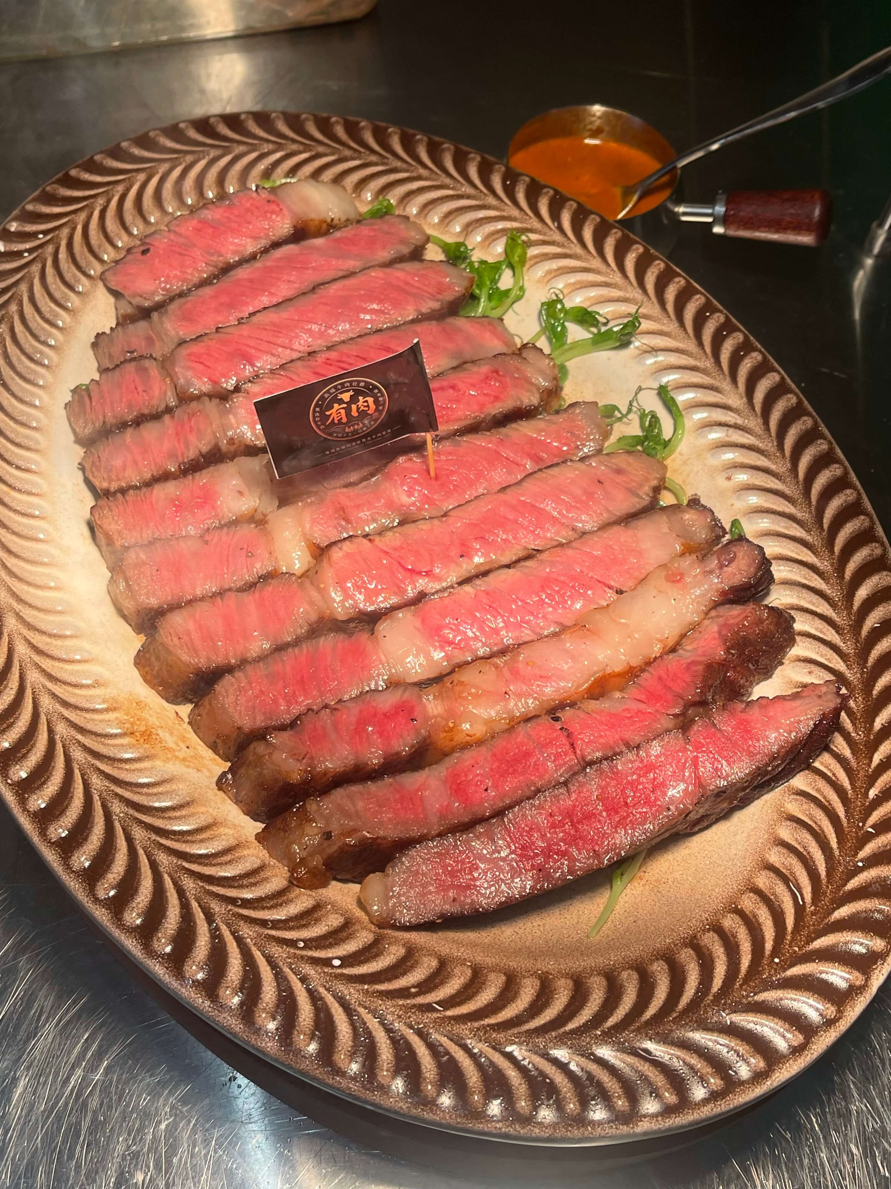 有肉实拍：牛排切片与品牌桌牌